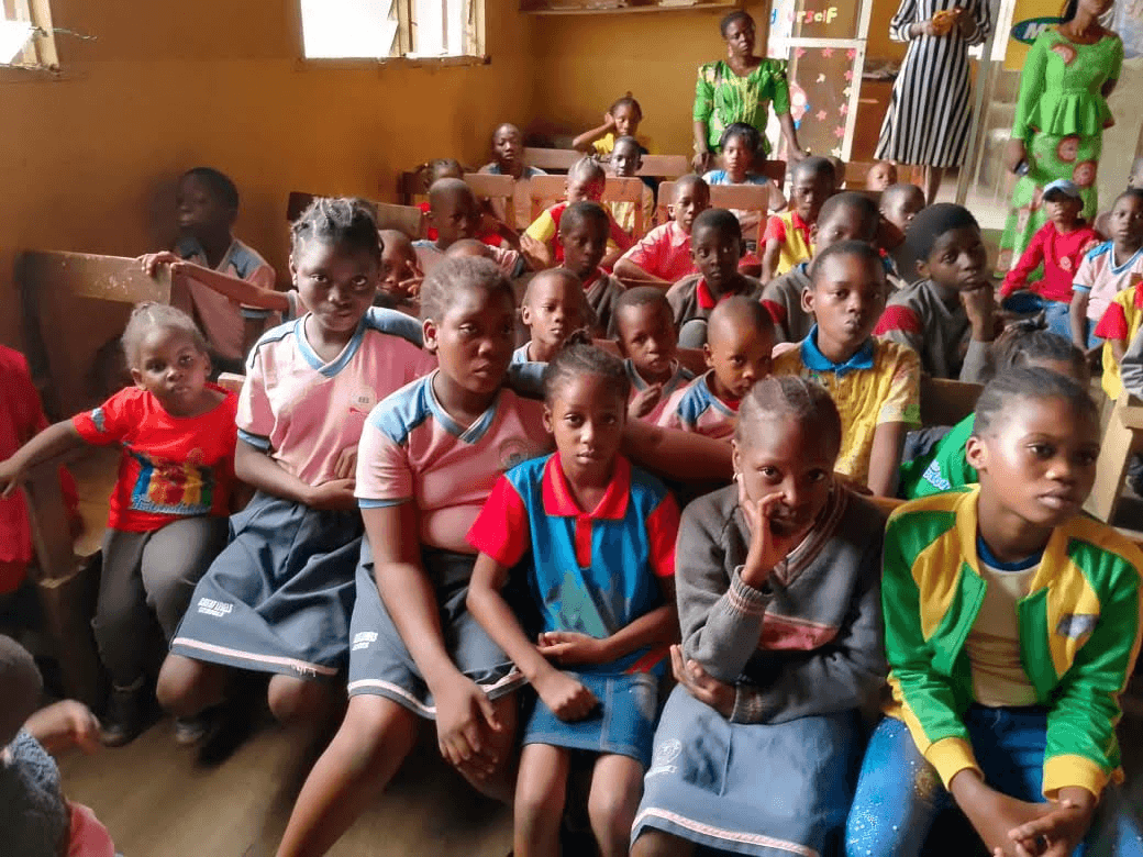 A close view of children seated on benches during the lesson.