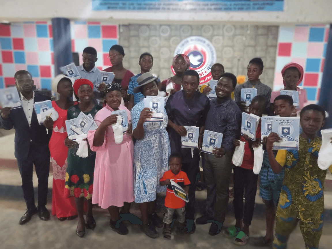 The group holding up their exercise books and socks towards the camera.